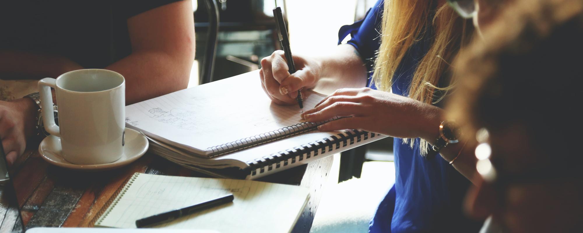 Person Writing on the Notebook