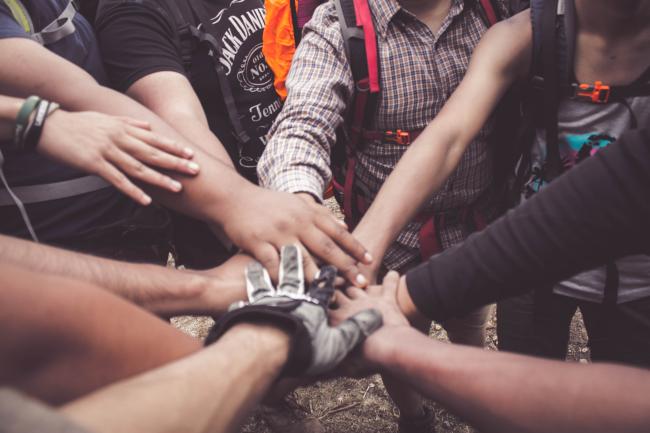 multi-cultural people with hands in a circle